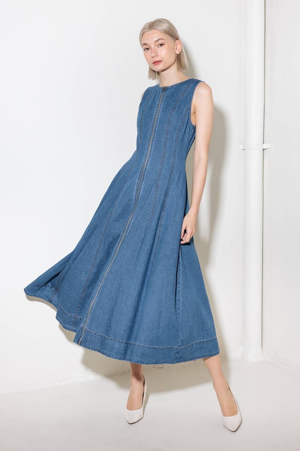 A washed denim midi dress featuring round neckline, sleeveless and front zipper closure.