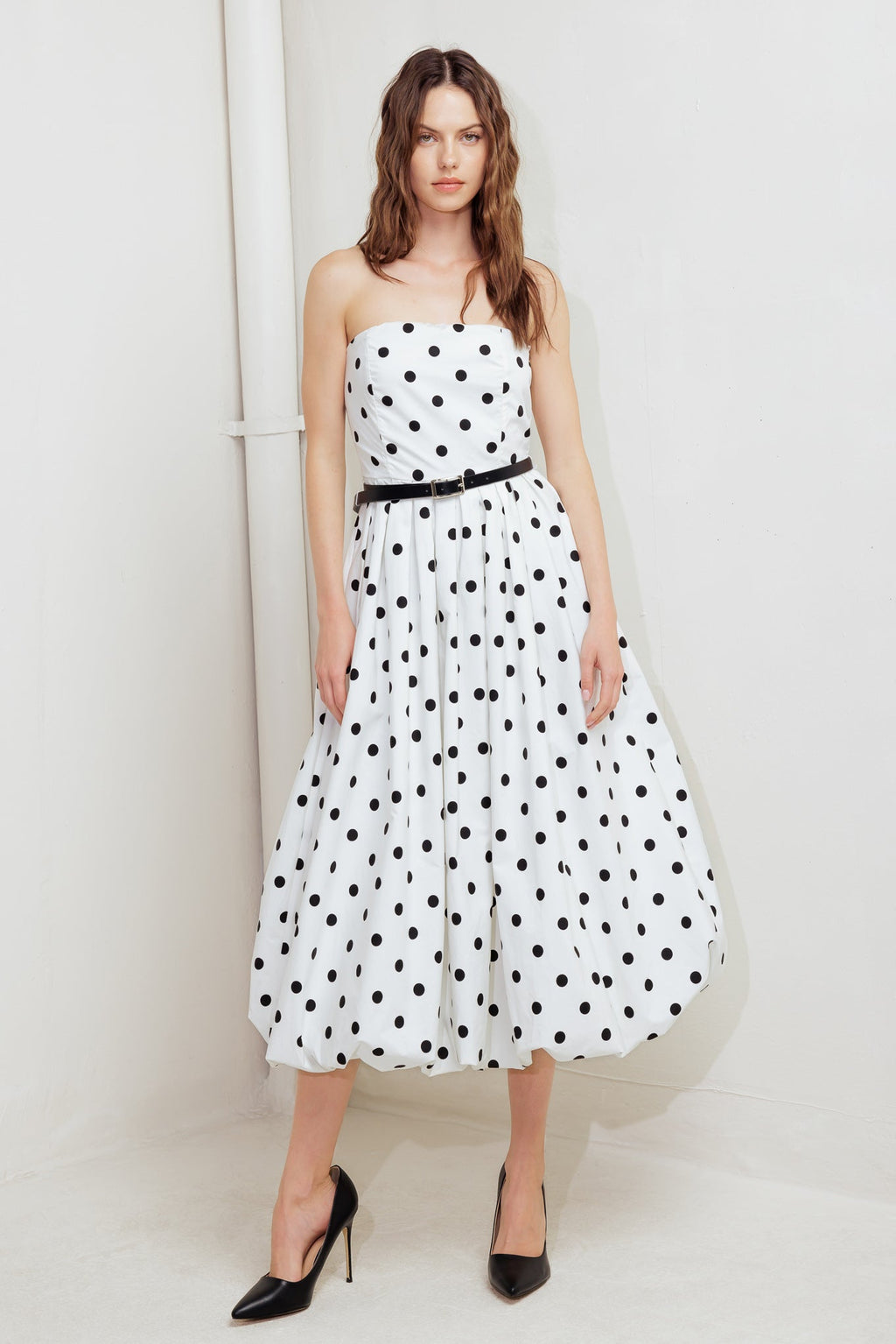 A polka dotted printed woven midi dress featuring strapless, contrasting belt, full skirt, bubble hemline and back zipper closure