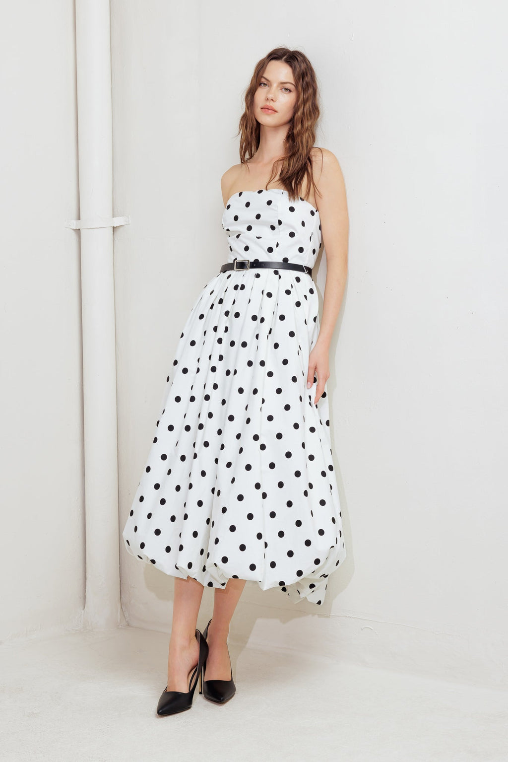 A polka dotted printed woven midi dress featuring strapless, contrasting belt, full skirt, bubble hemline and back zipper closure