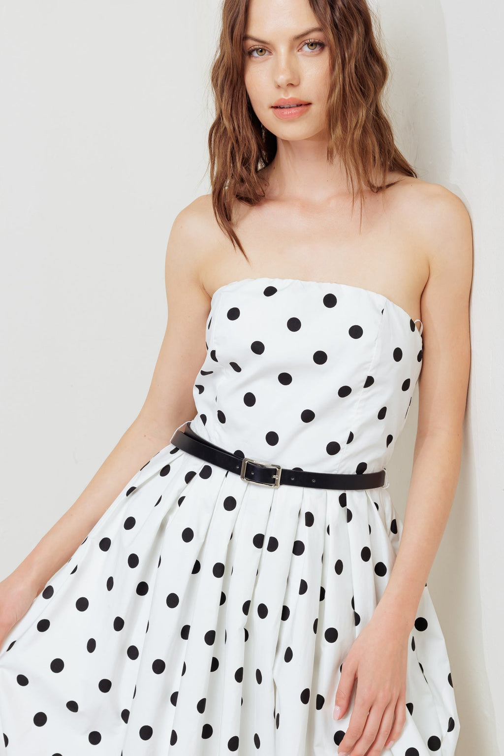 A polka dotted printed woven midi dress featuring strapless, contrasting belt, full skirt, bubble hemline and back zipper closure