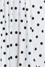 A polka dotted printed woven midi dress featuring strapless, contrasting belt, full skirt, bubble hemline and back zipper closure