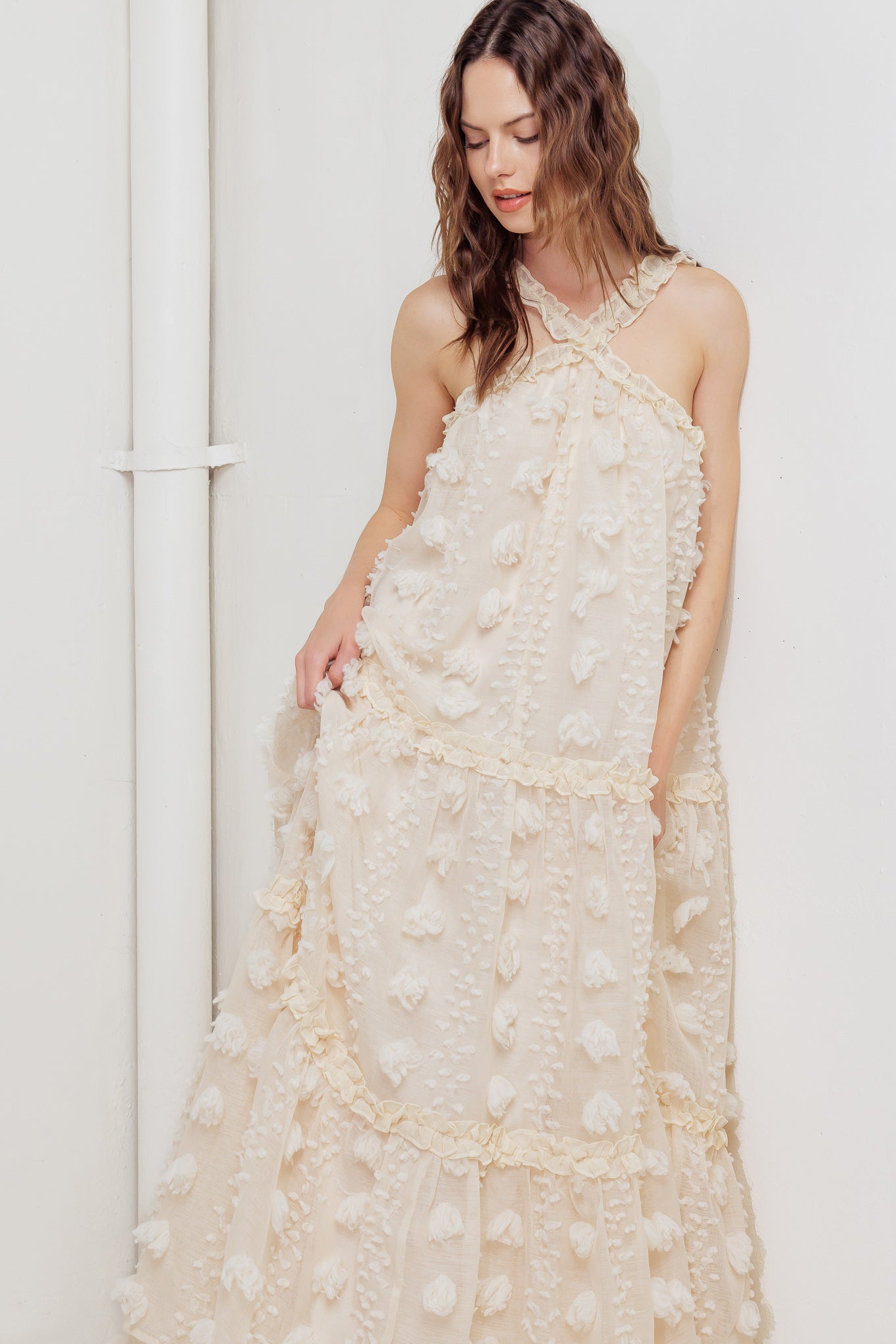 A cream textured woven ankle dress featuring ruffled cross front and tiered skirt