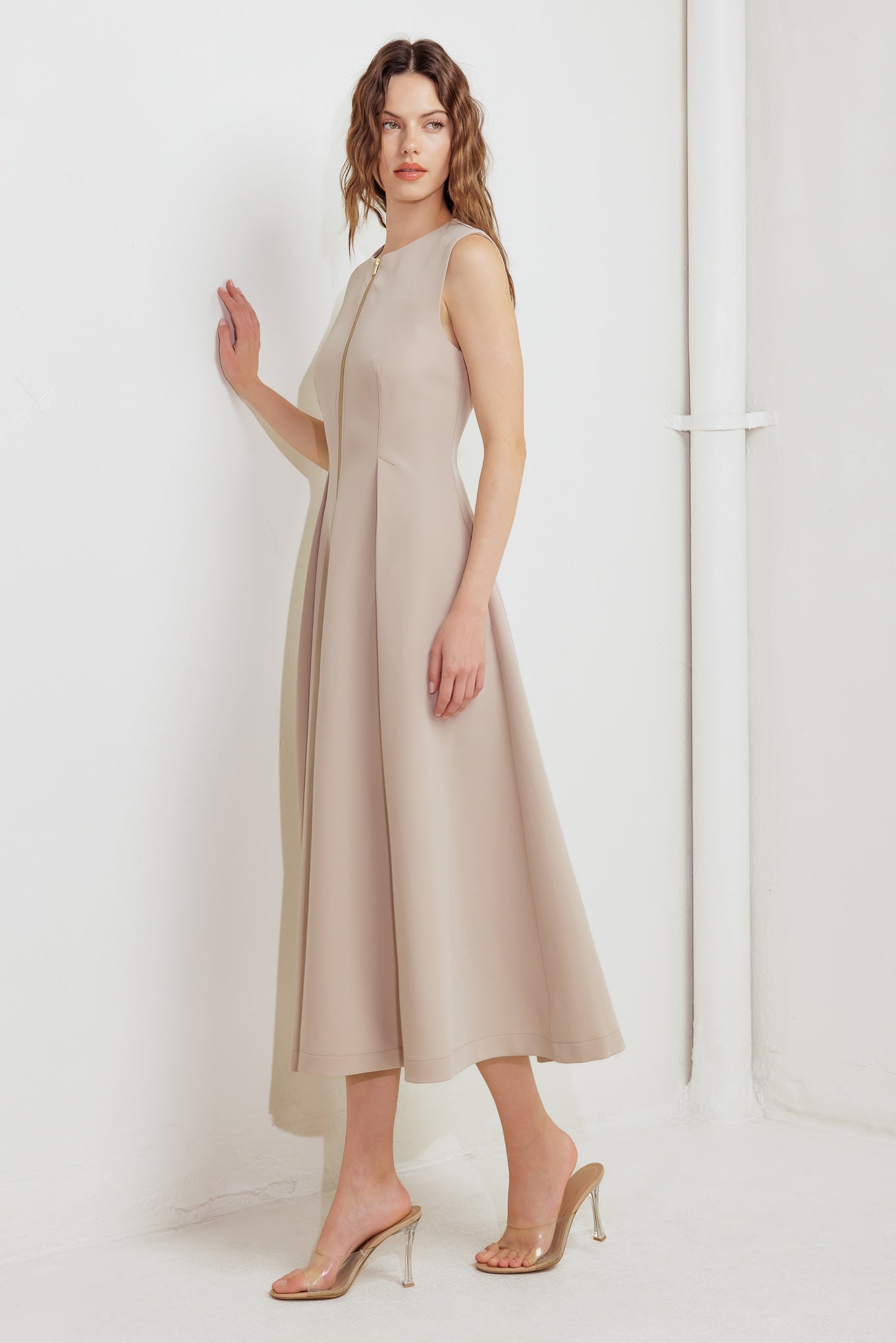 A solid woven midi dress featuring round neckline, sleeveless, front zipper closure and full skirt