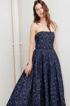 A denim midi dress featuring strapless straight neckline, self belt, full skirt and back zipper closure