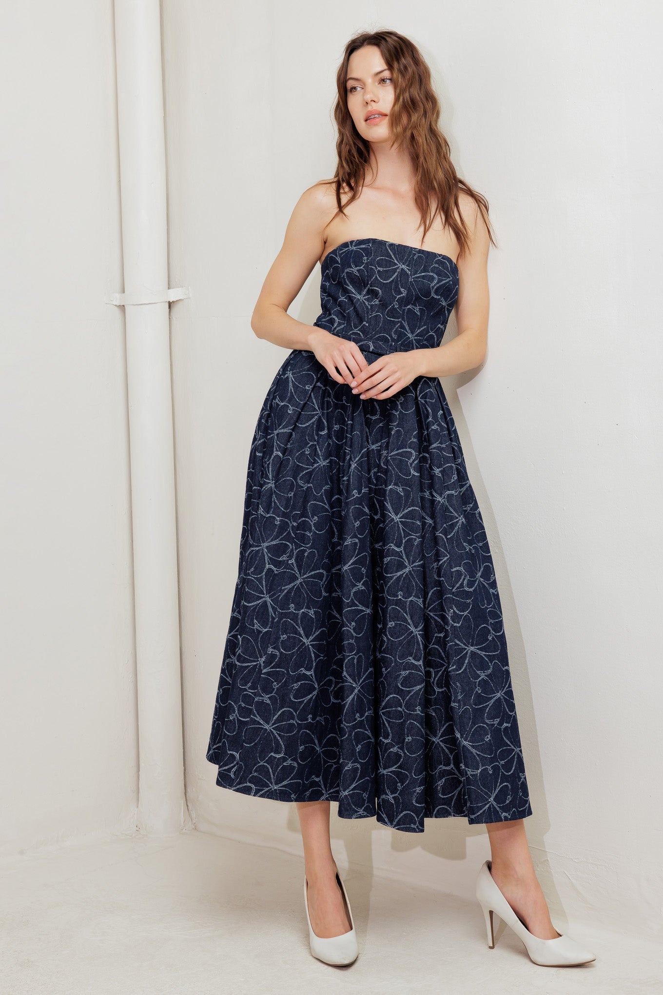 A denim midi dress featuring strapless straight neckline, self belt, full skirt and back zipper closure