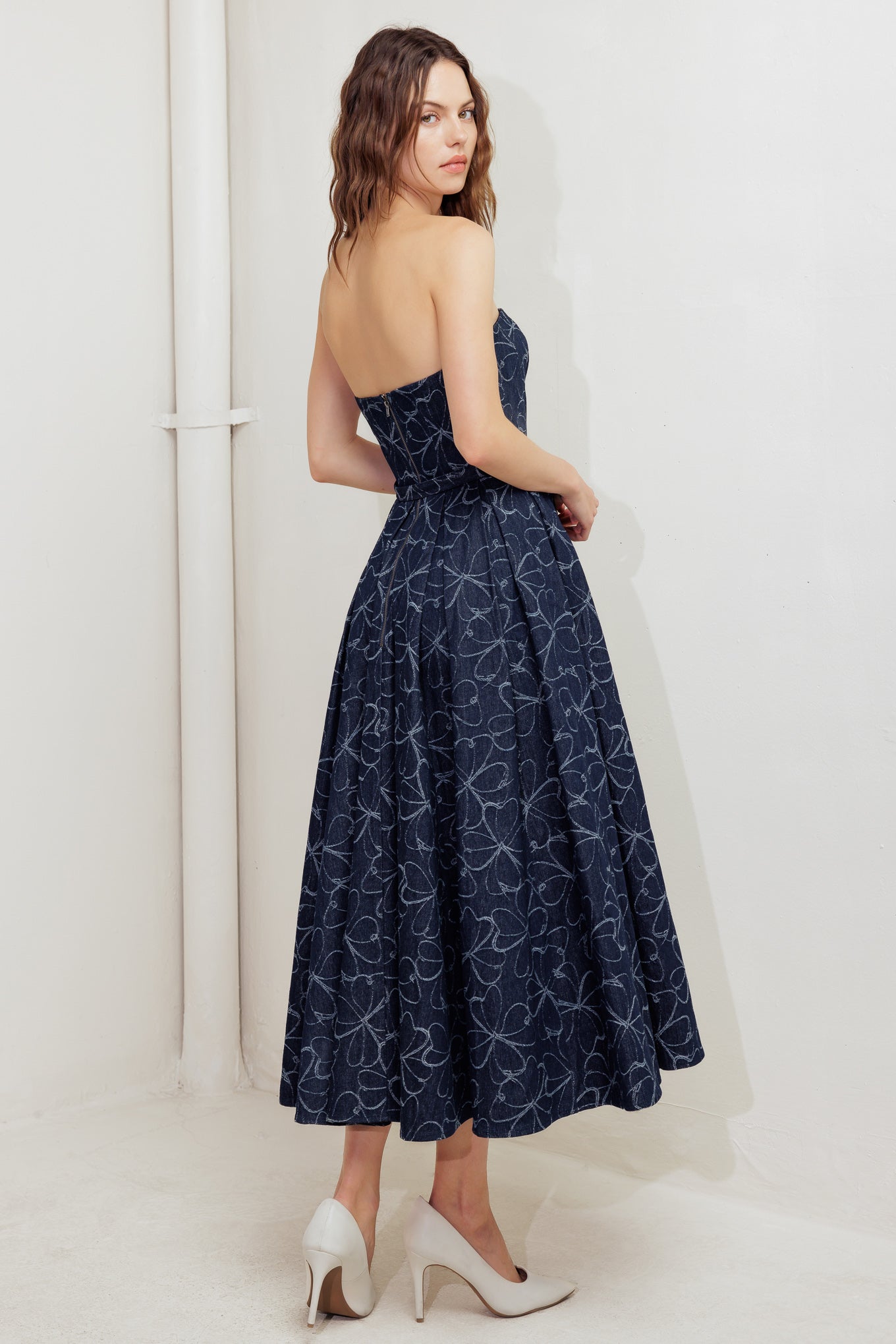 A denim midi dress featuring strapless straight neckline, self belt, full skirt and back zipper closure