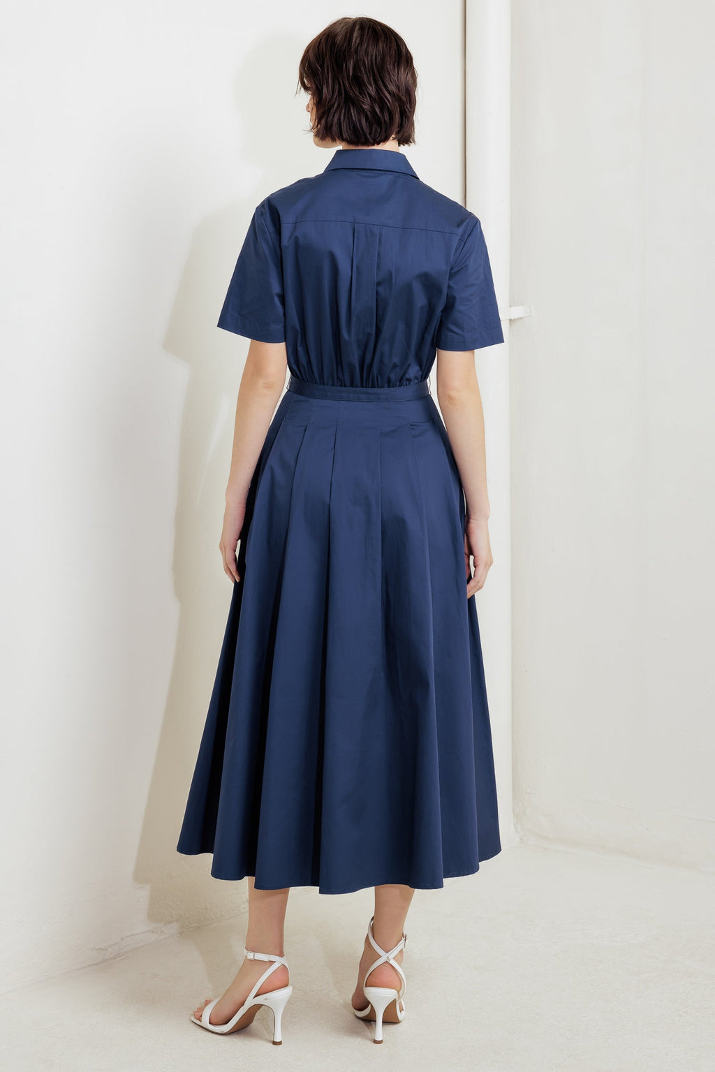 A solid woven midi dress featuring collar, short sleeve, front pocket, button down, self-belt and full skirt
