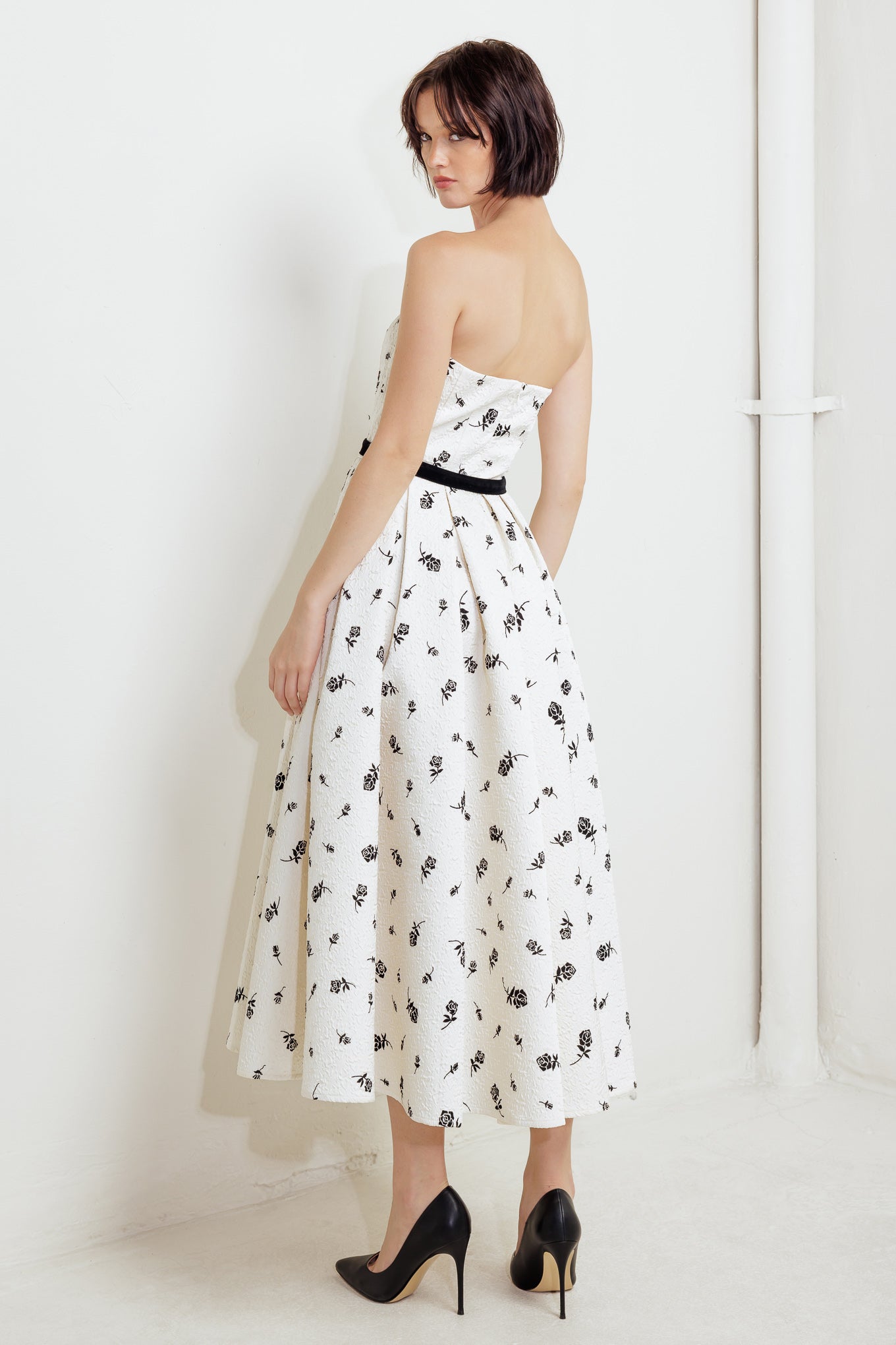 A printed textured woven midi dress featuring strapless neckline, contrasting belt, full skirt and back zipper closure