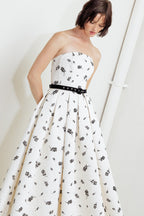 A printed textured woven midi dress featuring strapless neckline, contrasting belt, full skirt and back zipper closure