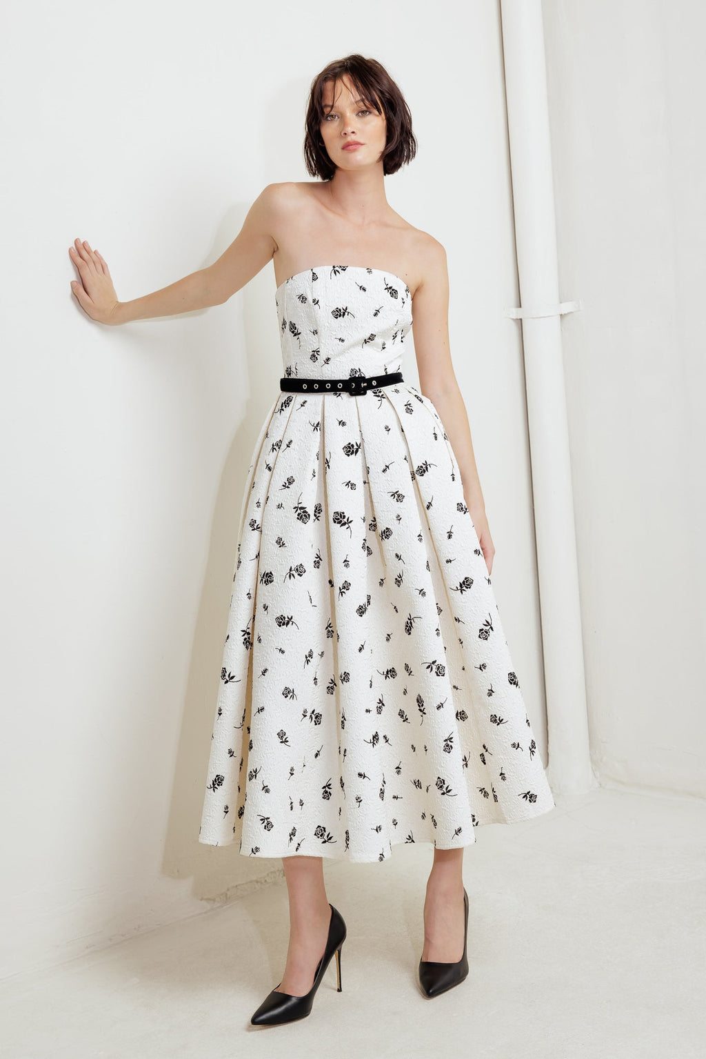 A printed textured woven midi dress featuring strapless neckline, contrasting belt, full skirt and back zipper closure