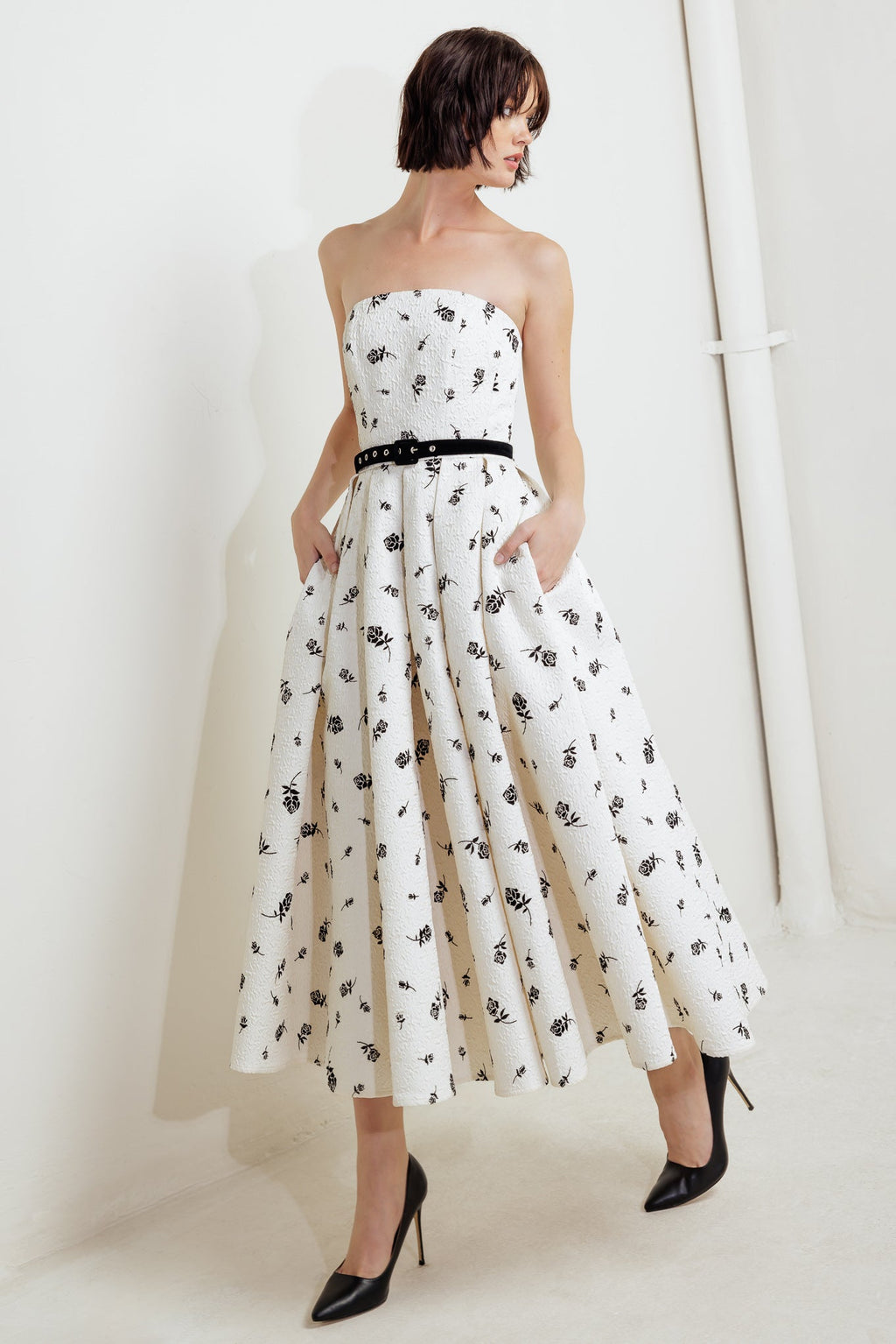 A printed textured woven midi dress featuring strapless neckline, contrasting belt, full skirt and back zipper closure