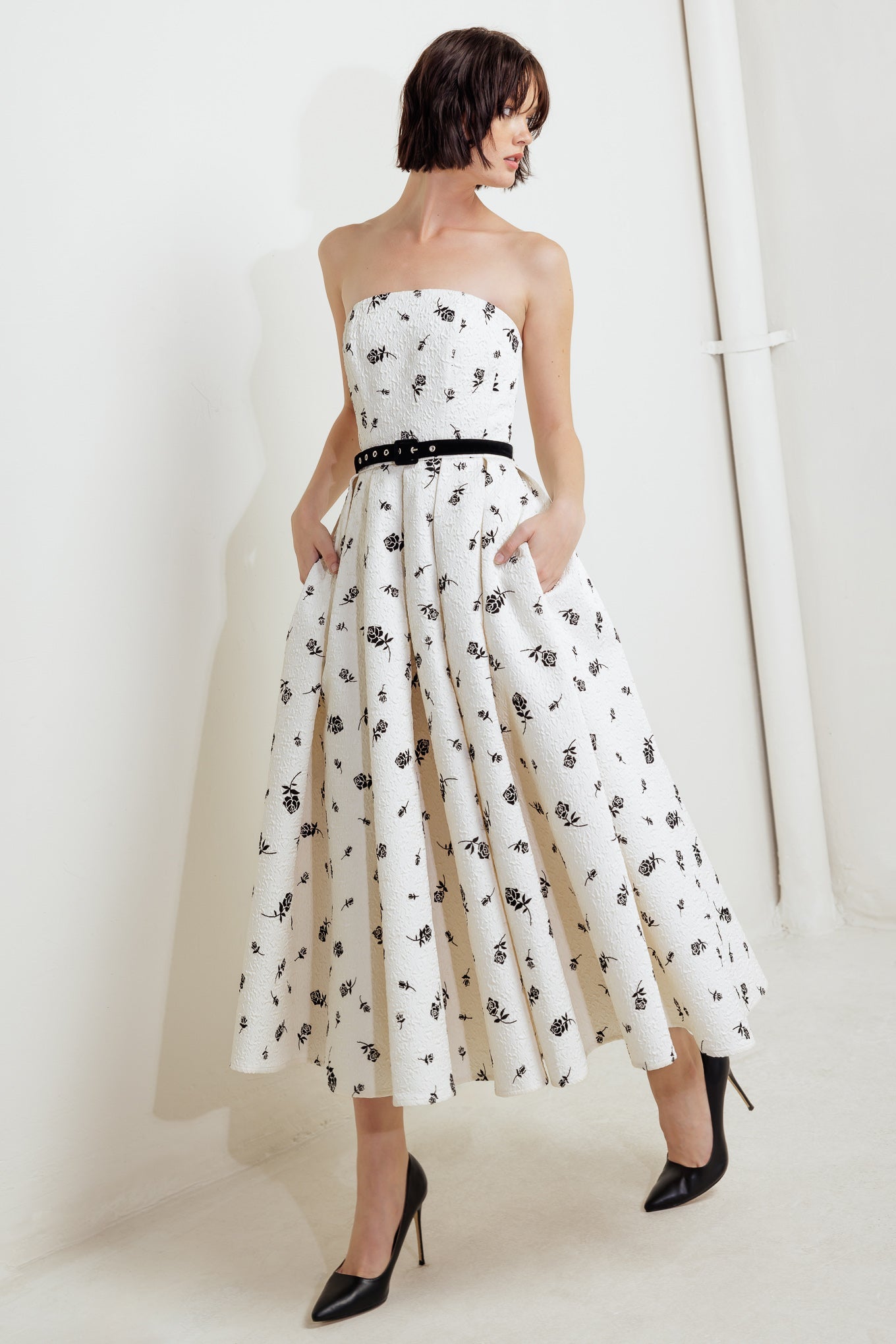 A printed textured woven midi dress featuring strapless neckline, contrasting belt, full skirt and back zipper closure