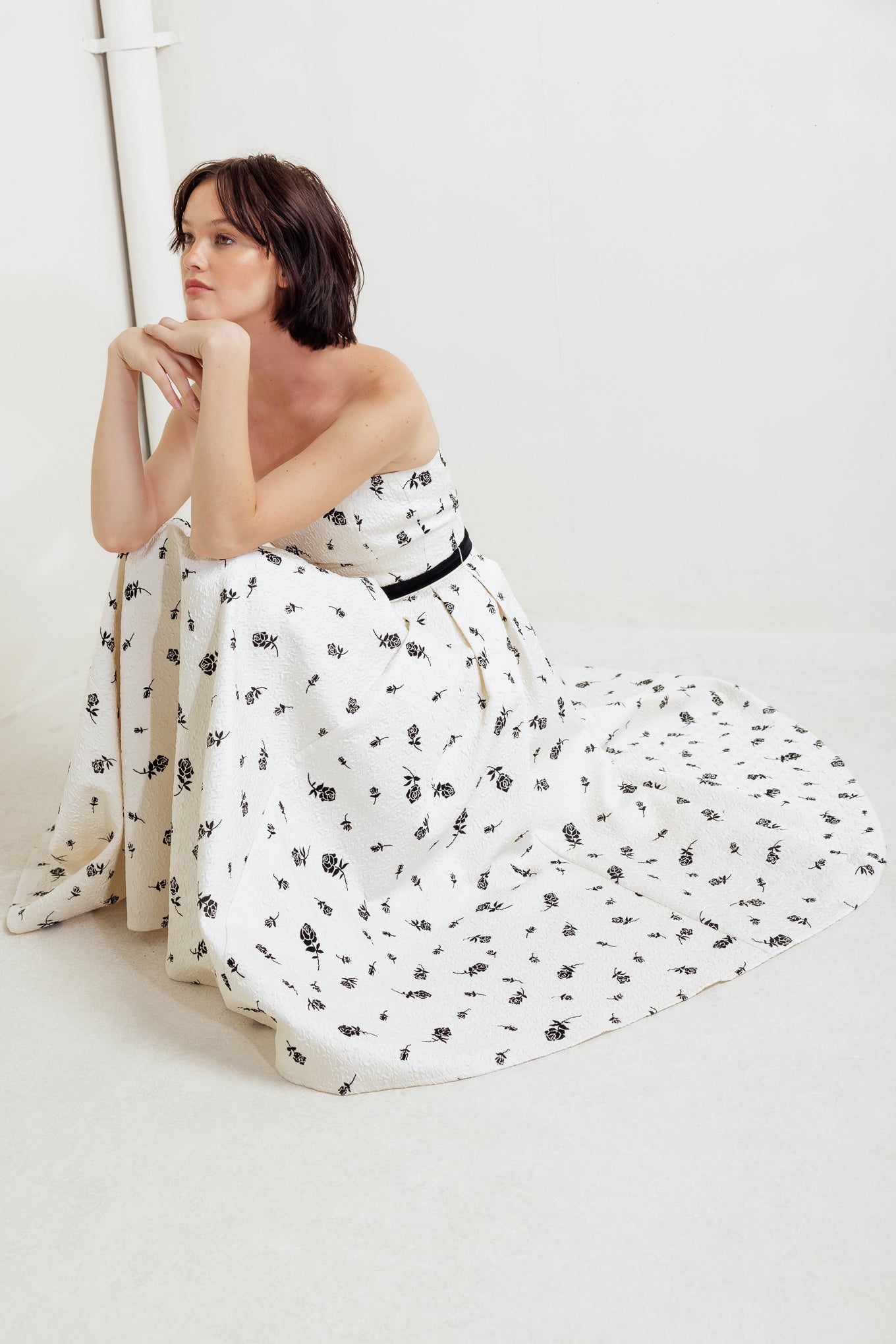 A printed textured woven midi dress featuring strapless neckline, contrasting belt, full skirt and back zipper closure