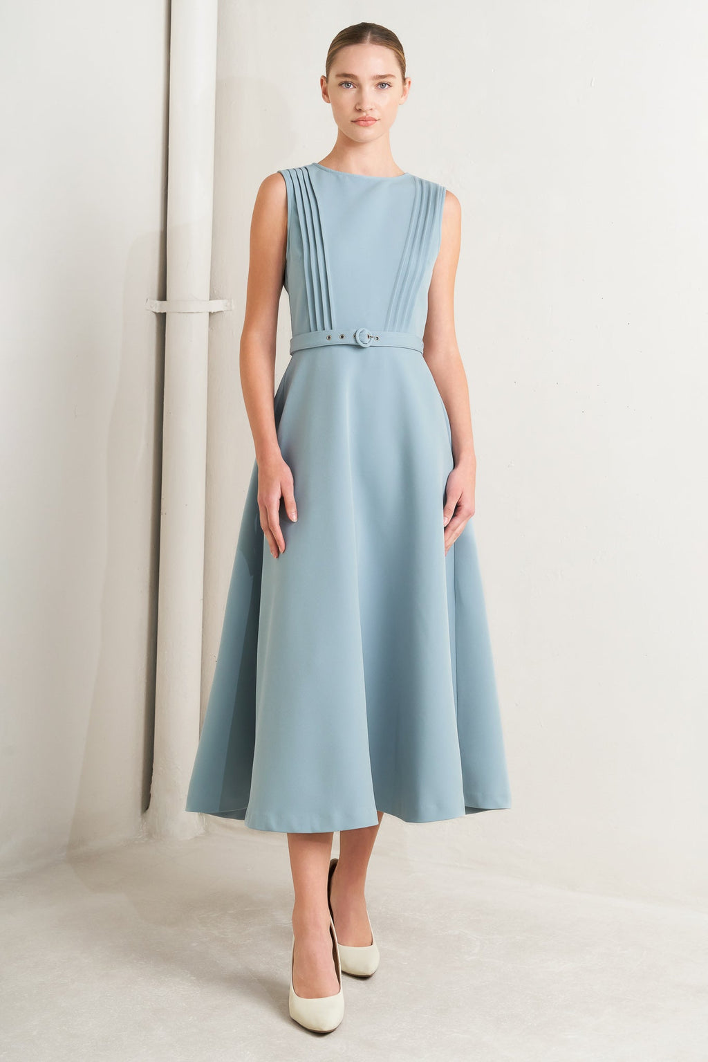 Solid soft blue midi dress with round neck, pintuck front & self-belt. Circle skirt, sleeveless.