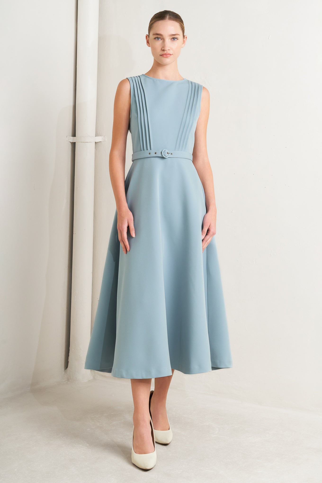 Solid soft blue midi dress with round neck, pintuck front & self-belt. Circle skirt, sleeveless.