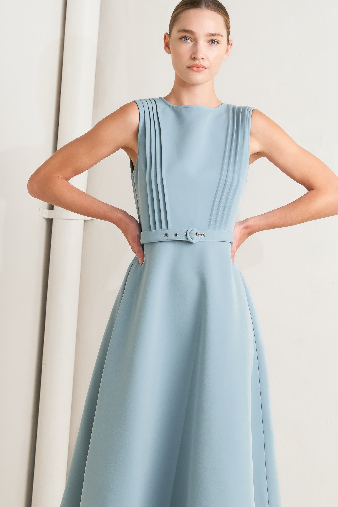 Solid soft blue midi dress with round neck, pintuck front & self-belt. Circle skirt, sleeveless.