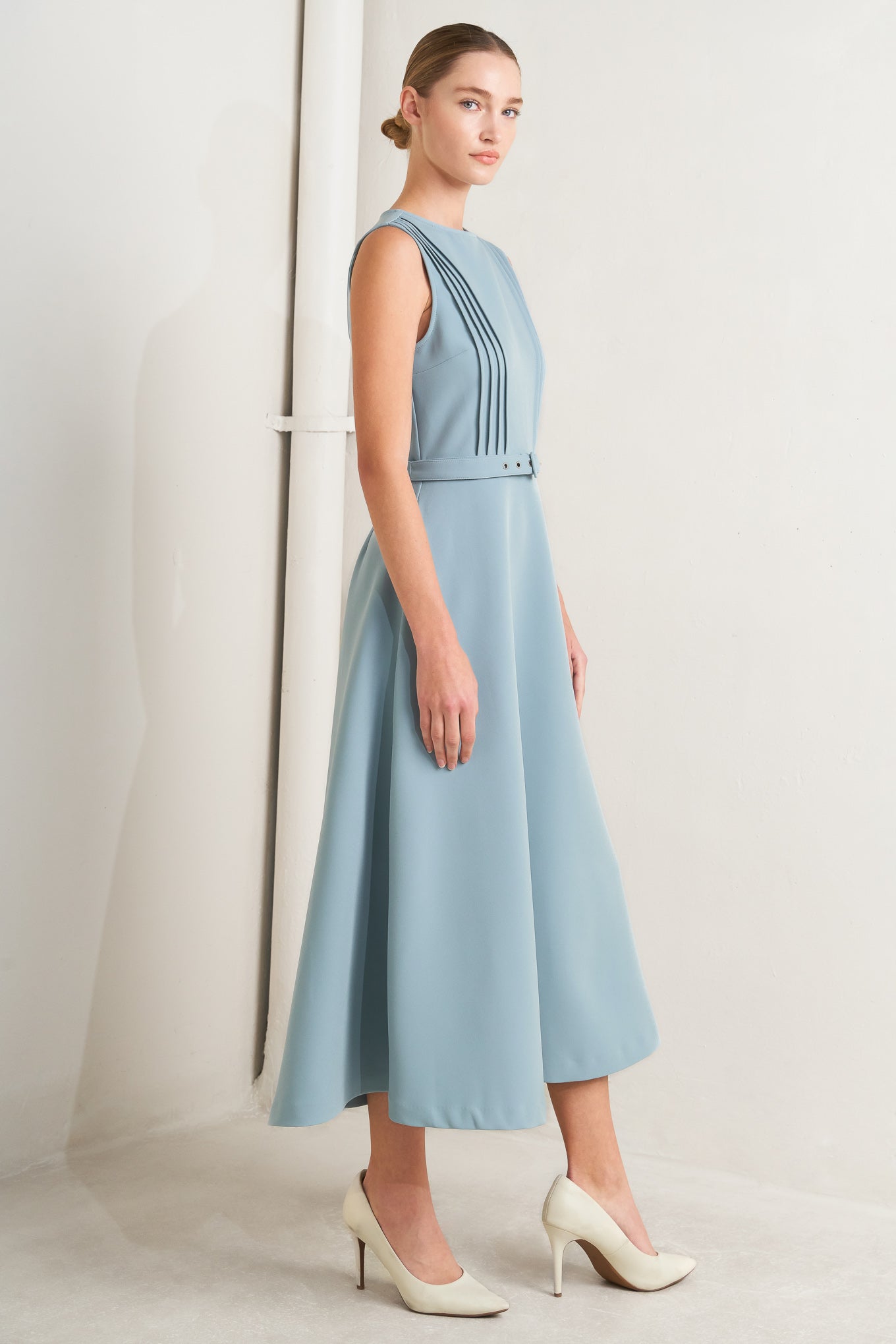 Solid soft blue midi dress with round neck, pintuck front & self-belt. Circle skirt, sleeveless.