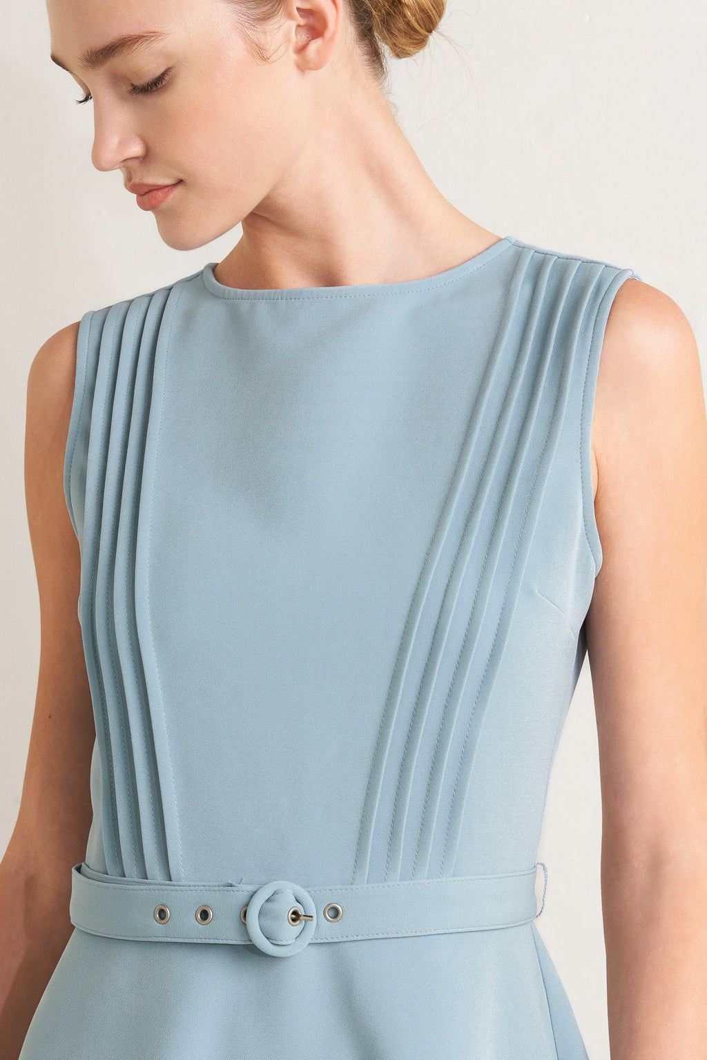 Solid soft blue midi dress with round neck, pintuck front & self-belt. Circle skirt, sleeveless.