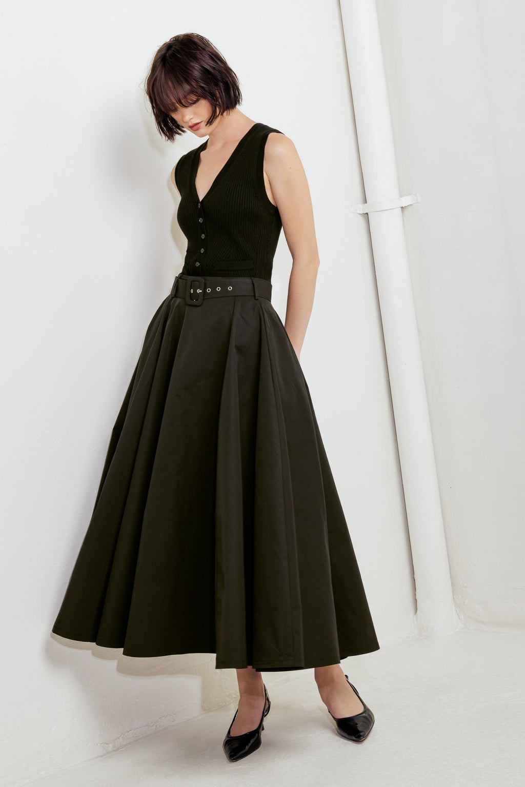 A solid black woven full midi skirt featuring self-belt and side zipper closure