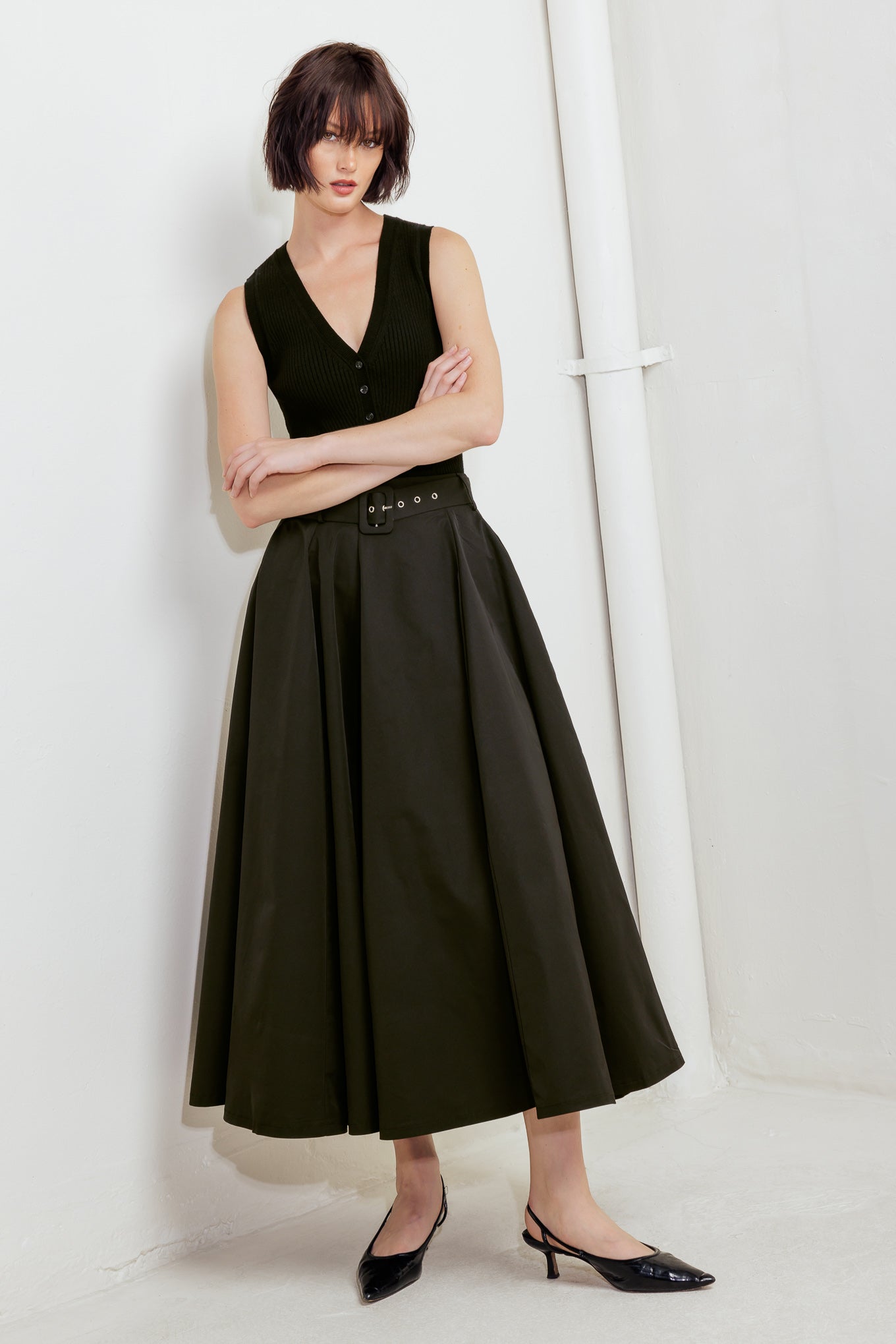 A solid black woven full midi skirt featuring self-belt and side zipper closure