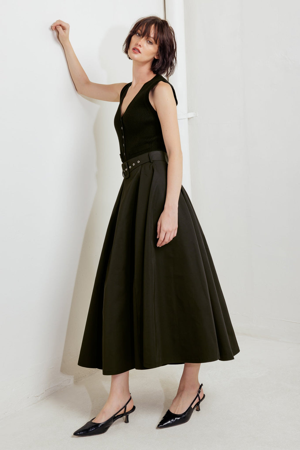 A solid black woven full midi skirt featuring self-belt and side zipper closure