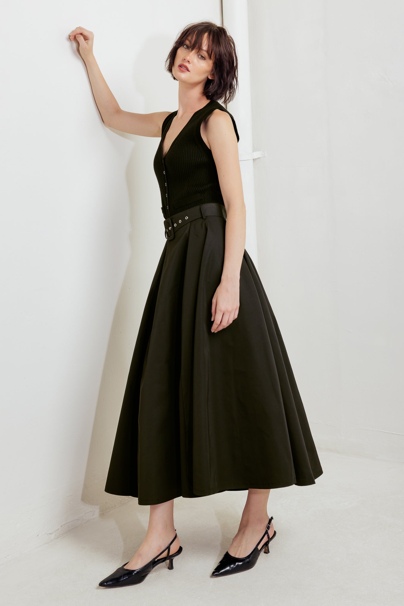 A solid black woven full midi skirt featuring self-belt and side zipper closure