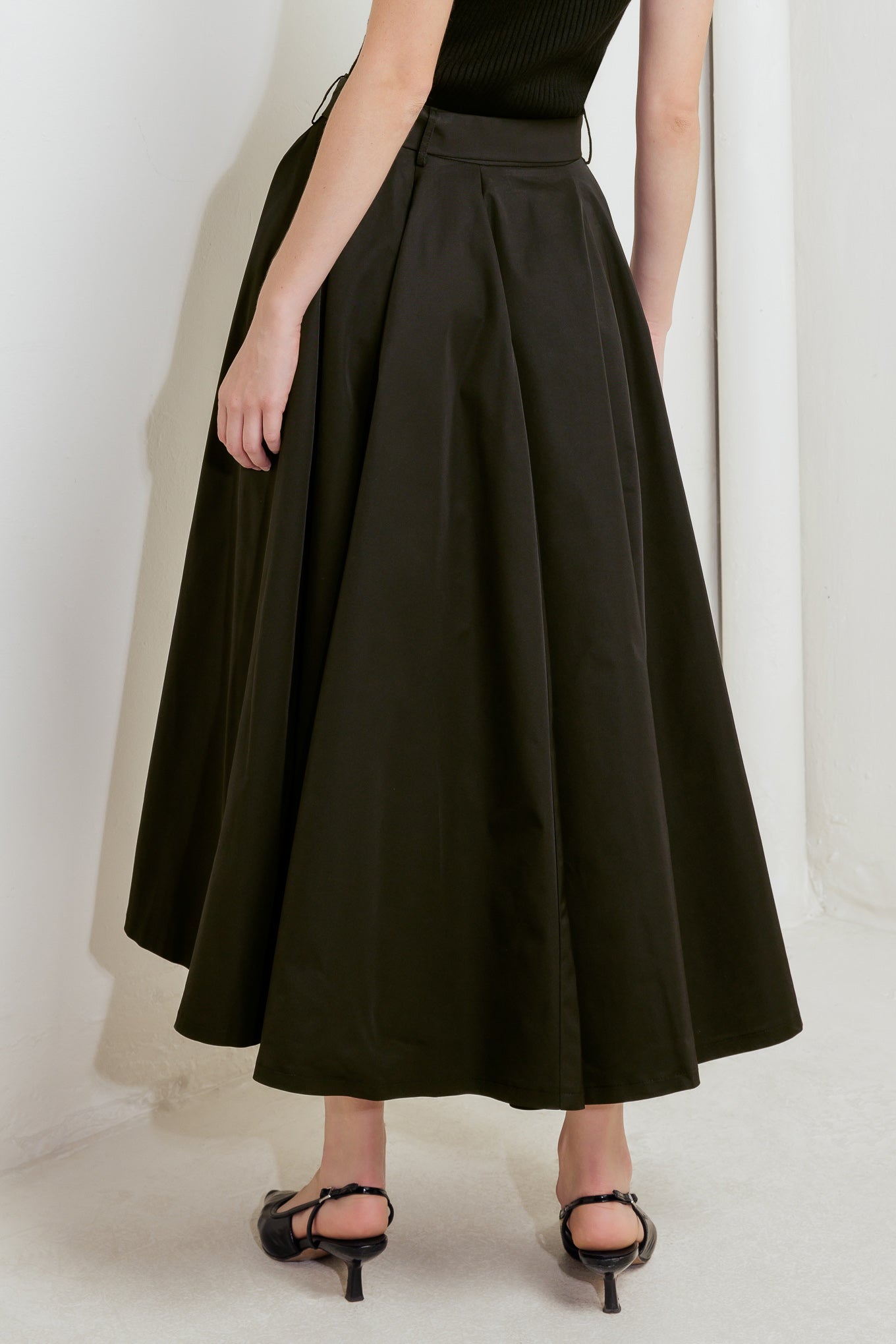 A solid black woven full midi skirt featuring self-belt and side zipper closure