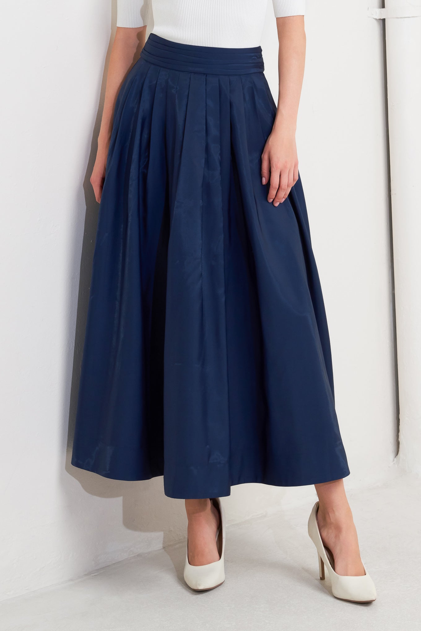 A solid navy woven pleated midi skirt with back zipper.