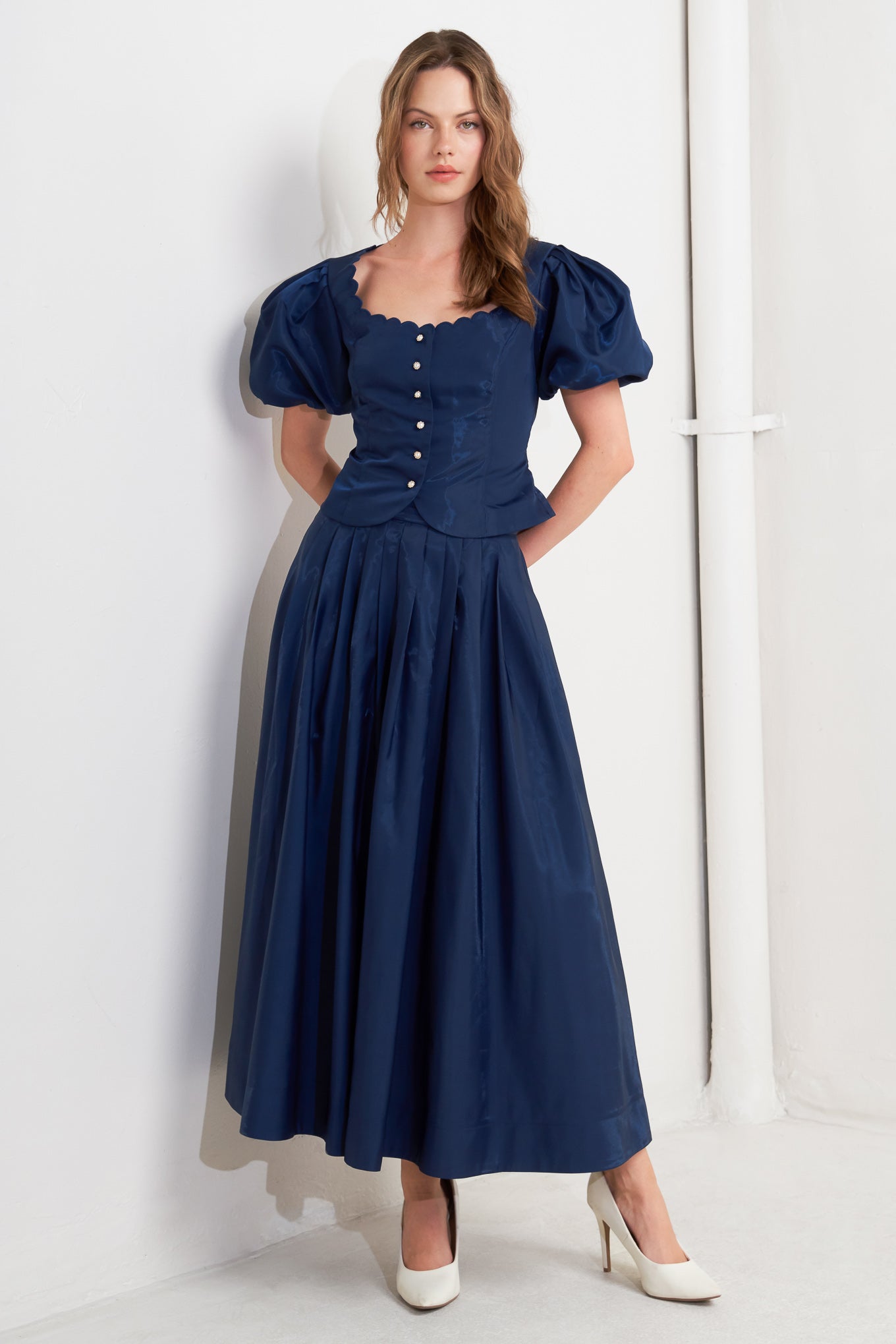 A solid navy woven pleated midi skirt with back zipper.