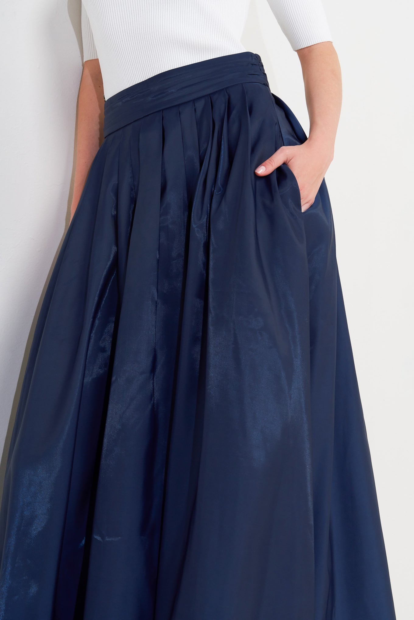 A solid navy woven pleated midi skirt with back zipper.