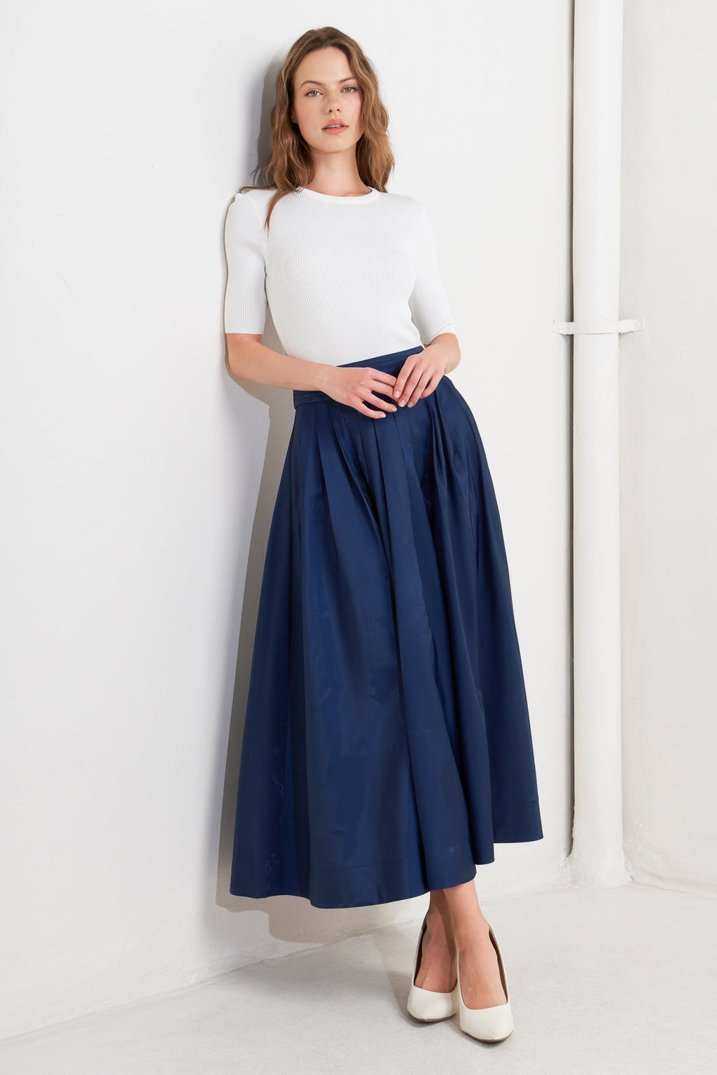 A solid navy woven pleated midi skirt with back zipper.