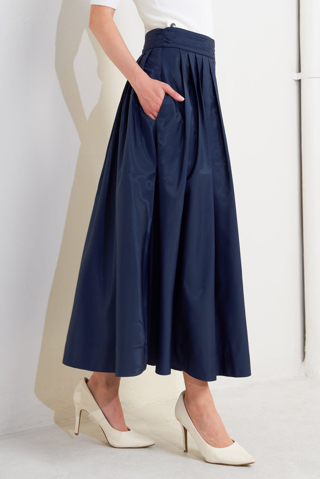 A solid navy woven pleated midi skirt with back zipper.