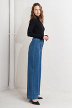 A washed denim pant featuring front zipper closure, side pocket and wide leg
