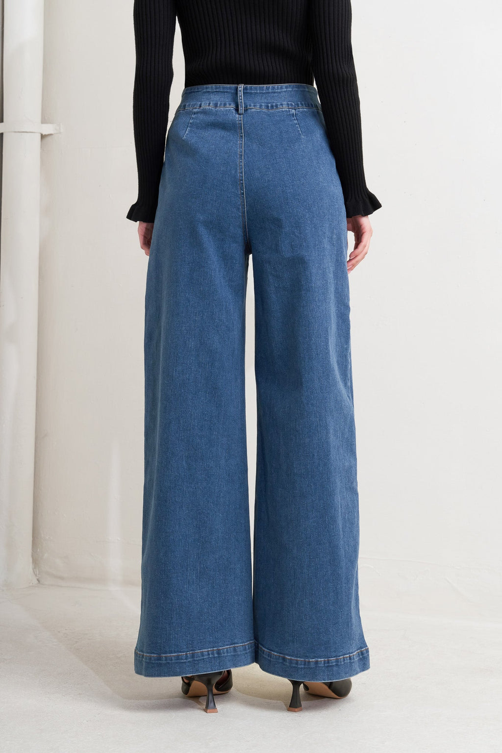 A washed denim pant featuring front zipper closure, side pocket and wide leg