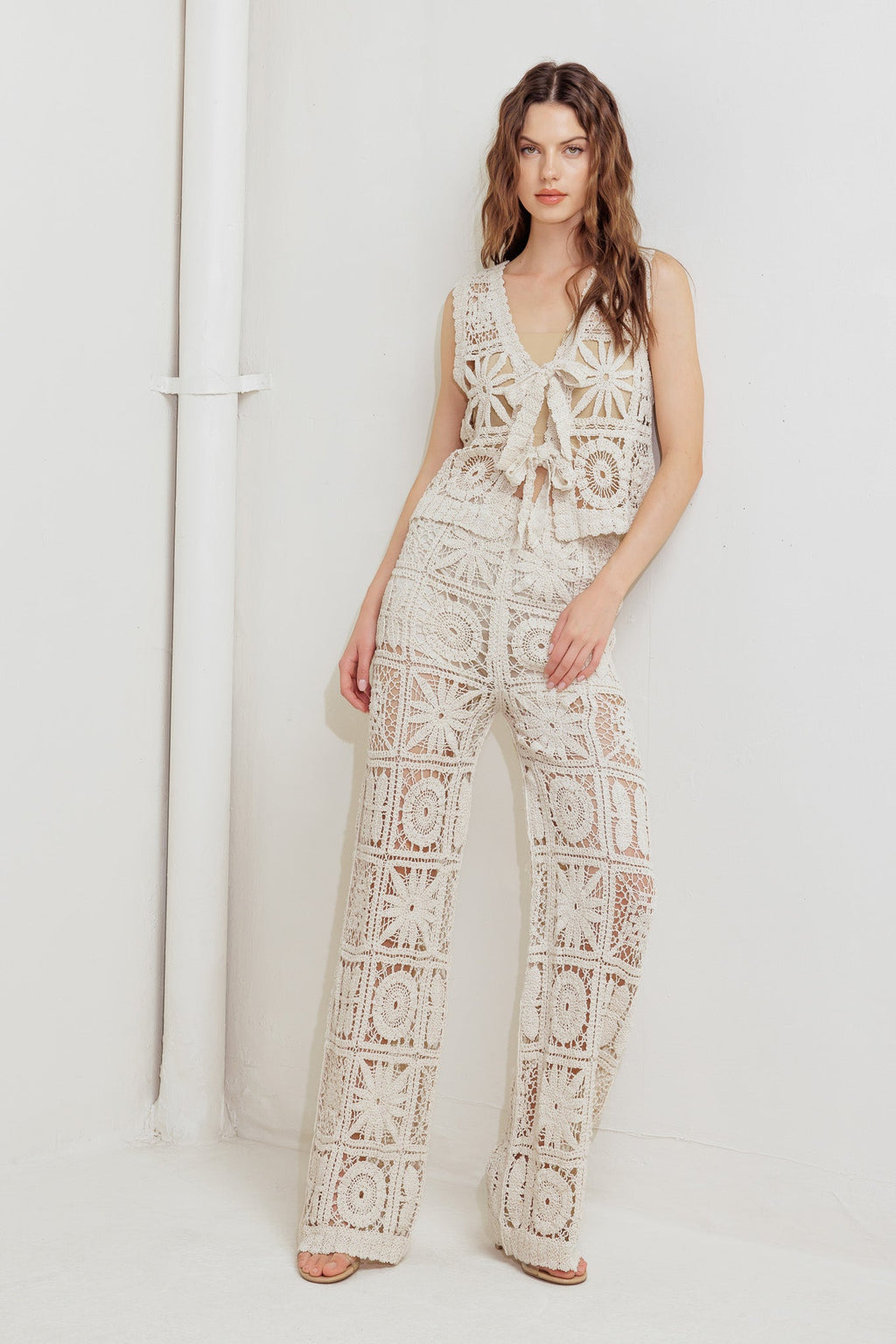 A crochet vest and pant set. Vest featuring front ties and elasticized waist pant