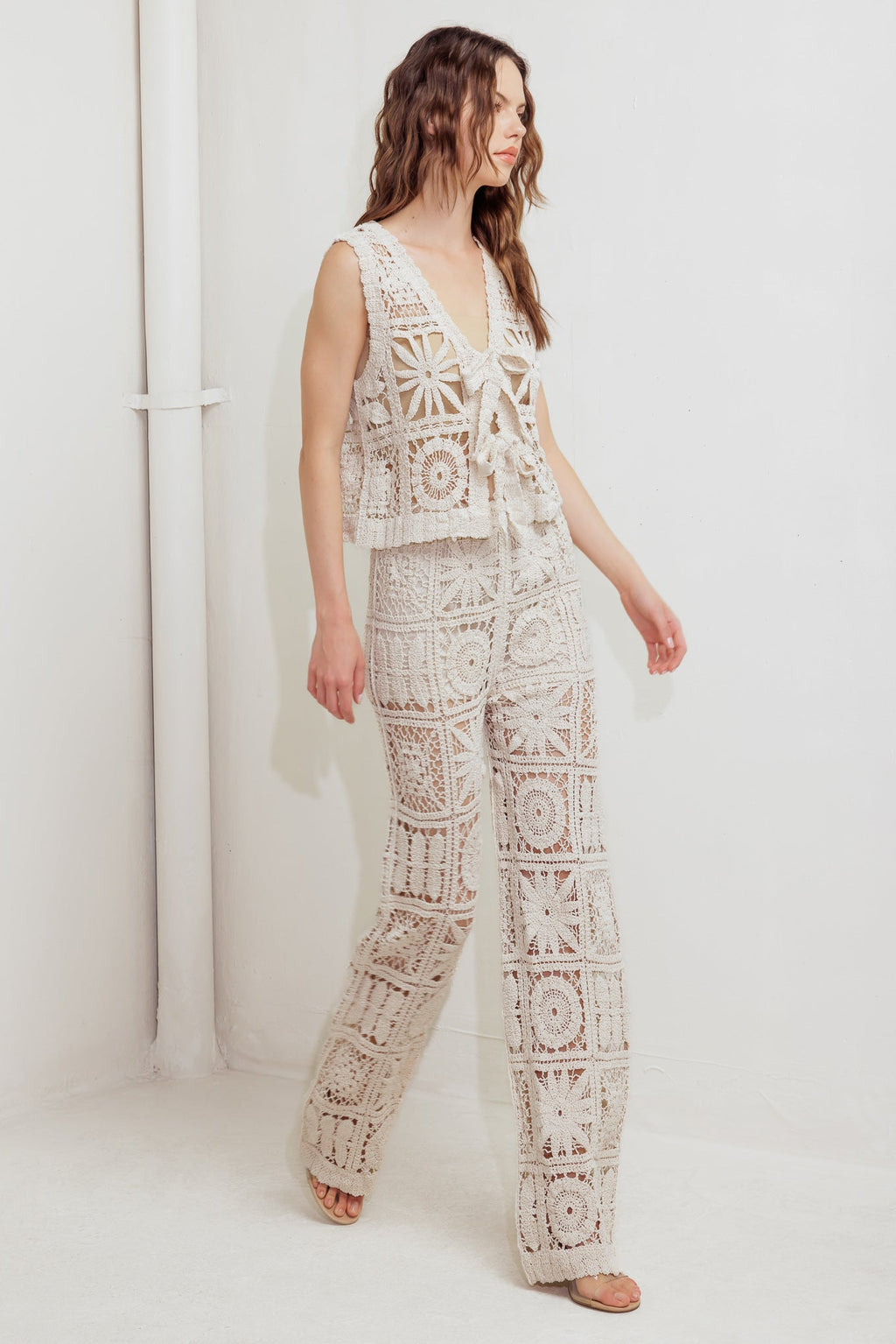 A crochet vest and pant set. Vest featuring front ties and elasticized waist pant