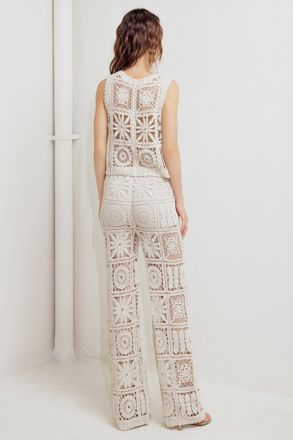 A crochet vest and pant set. Vest featuring front ties and elasticized waist pant