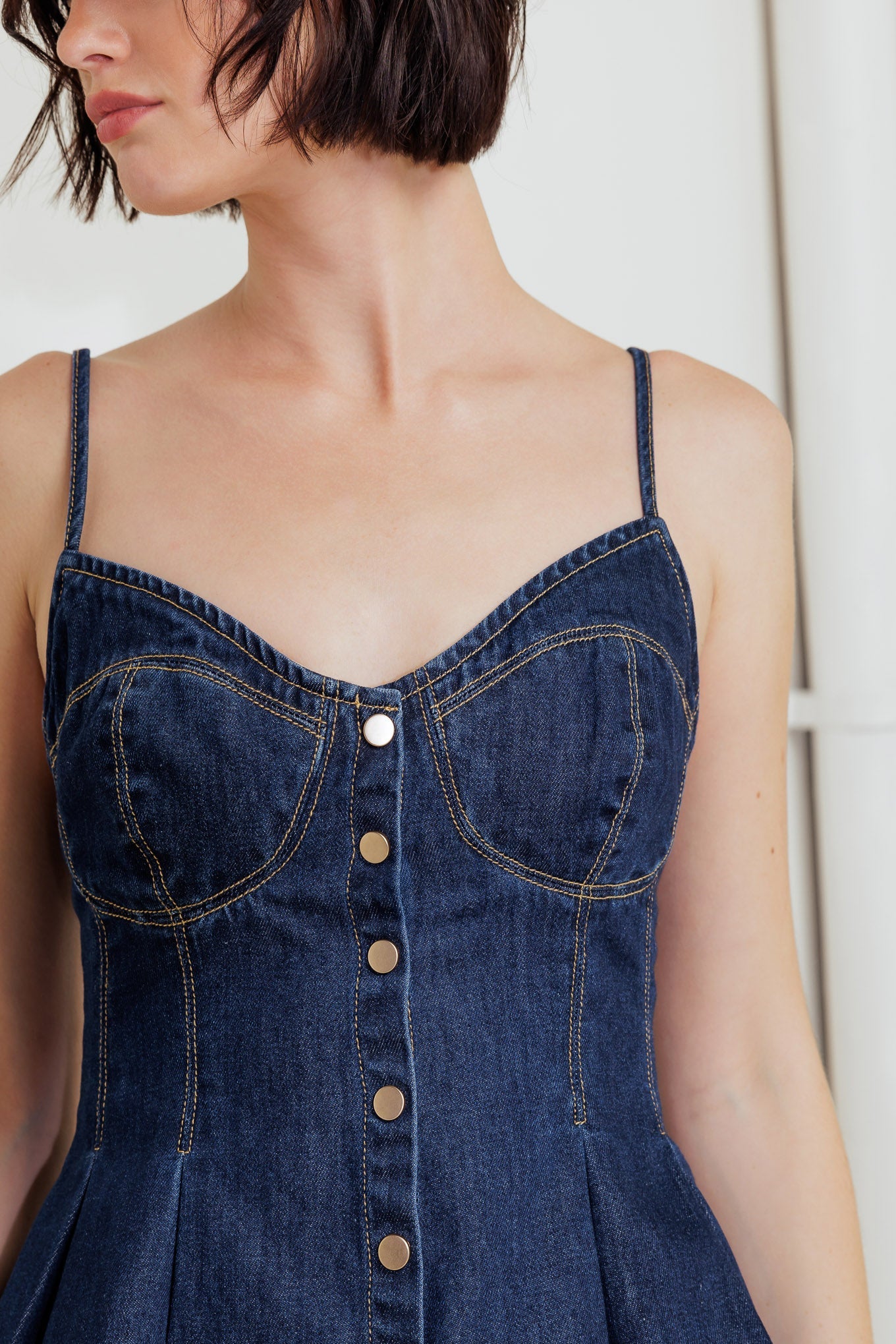 A lightweight denim cami top featuring front button down and peplum
