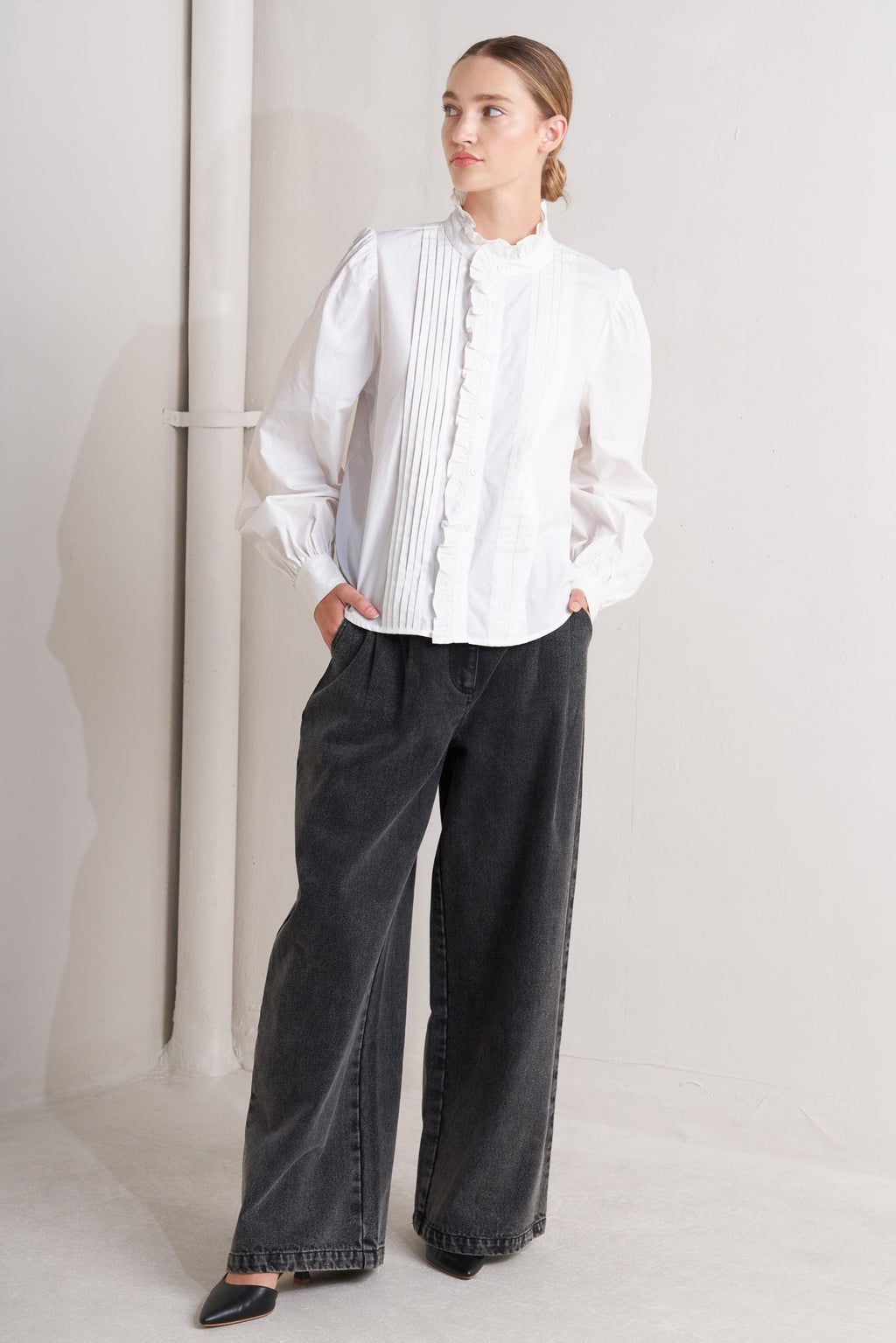 solid woven top featuring ruffled high neckline, long sleeve and front button down closure
