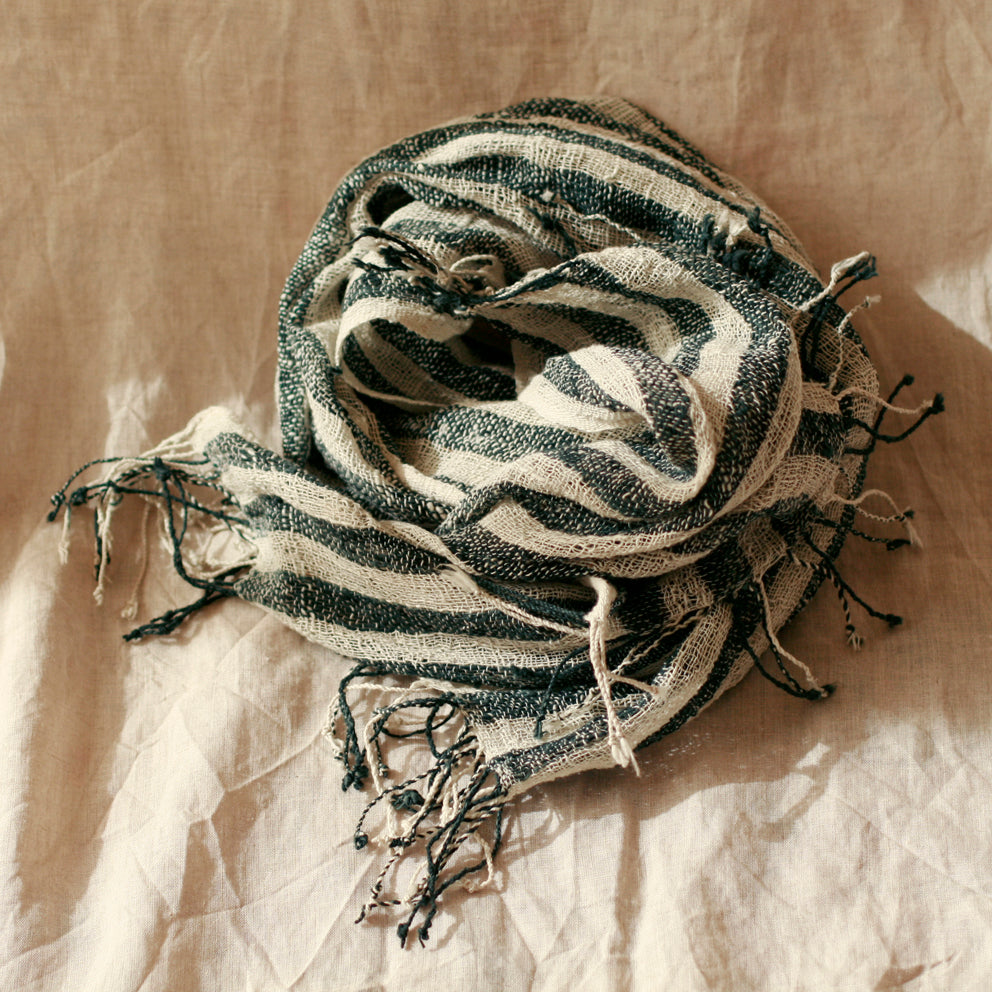 Striped scarf with tassels on a textured beige background