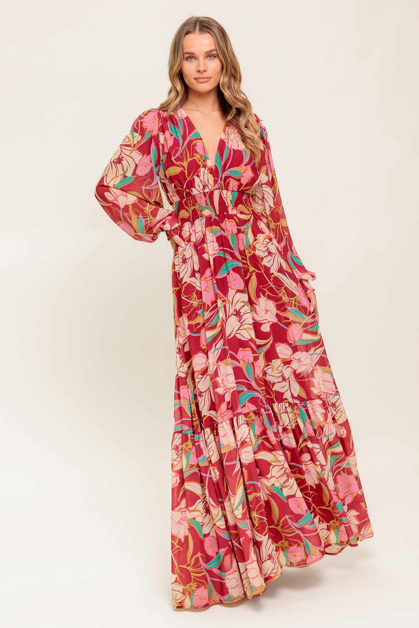 A printed woven maxi dress featuring V neckline, long sleeve with smocked cuff, smocked waist band and ruffled hemline