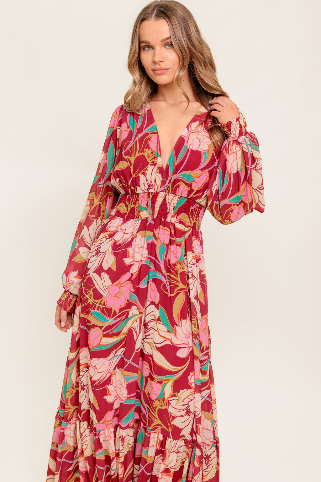 A printed woven maxi dress featuring V neckline, long sleeve with smocked cuff, smocked waist band and ruffled hemline