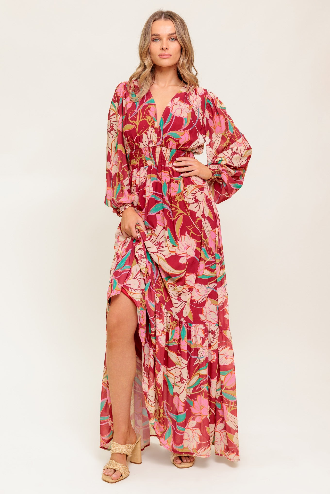 A printed woven maxi dress featuring V neckline, long sleeve with smocked cuff, smocked waist band and ruffled hemline