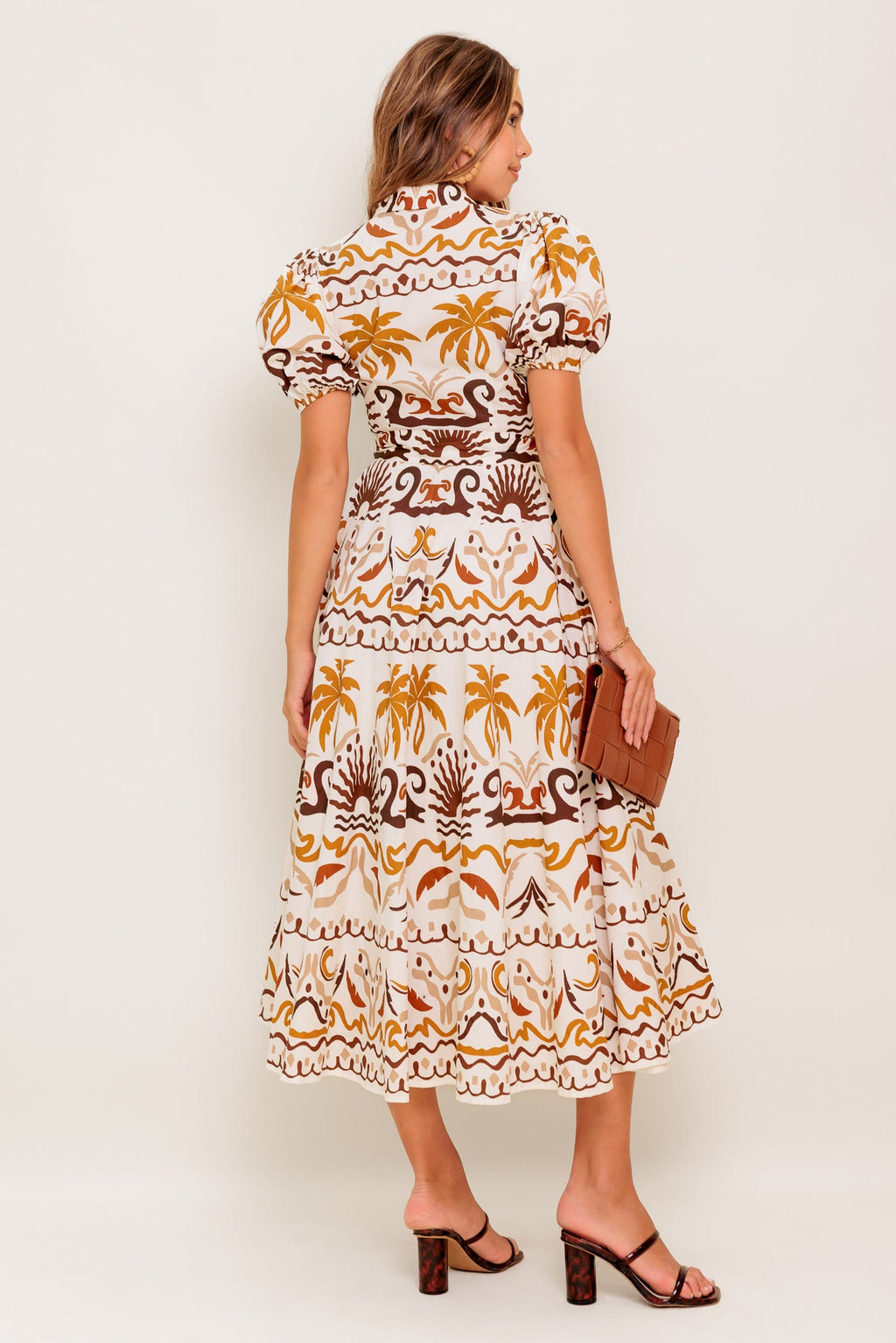 A printed woven midi dress featuring collar, short puff sleeve, button down, self sash and full skirt