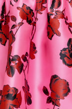 strapless mini dress showcases a pink floral pattern on woven fabric, designed with a full skirt and secured by a back zipper closure.