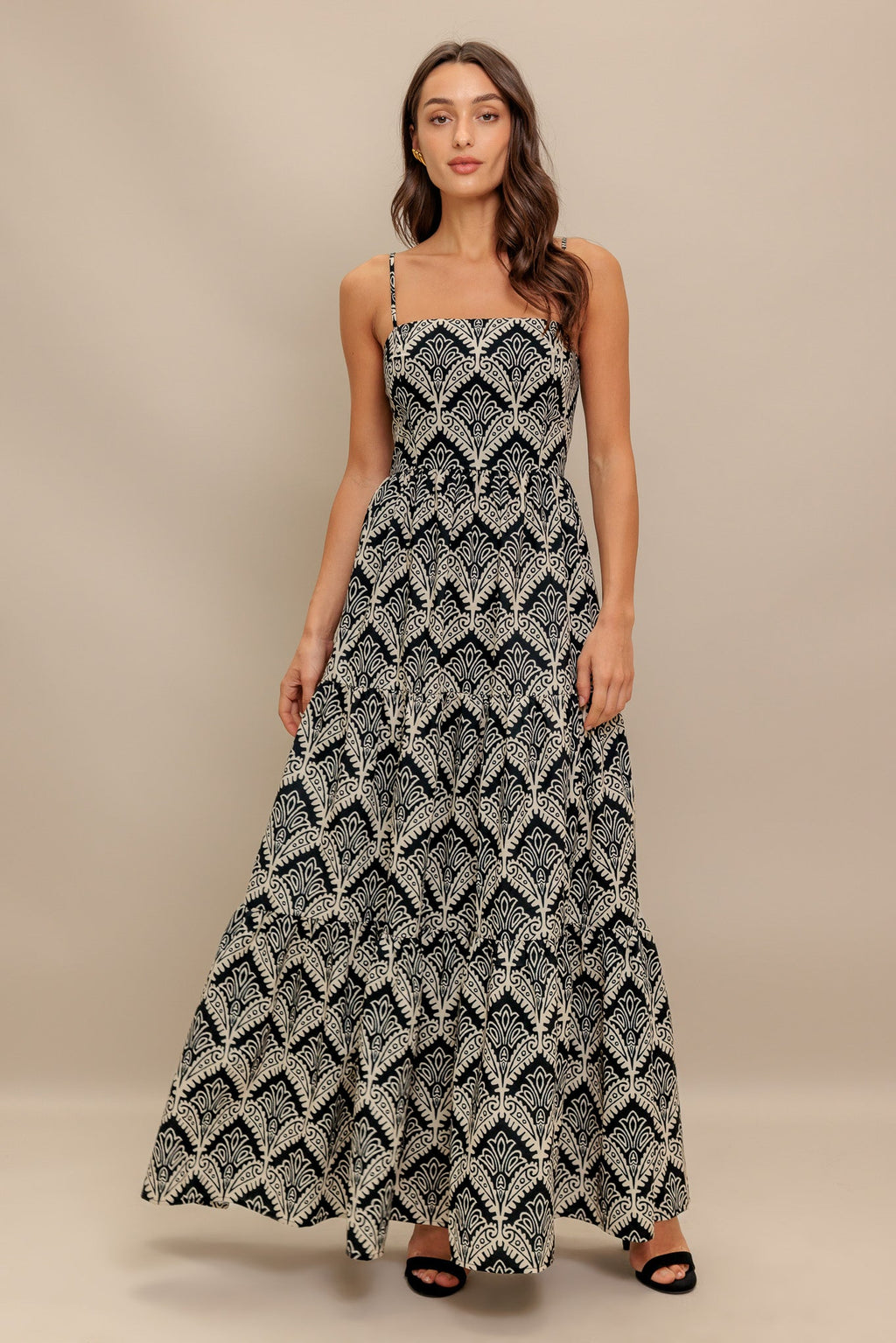 A printed black & ivory woven maxi dress featuring sweetheart neckline, straps, tiered skirt and smocked back bodice