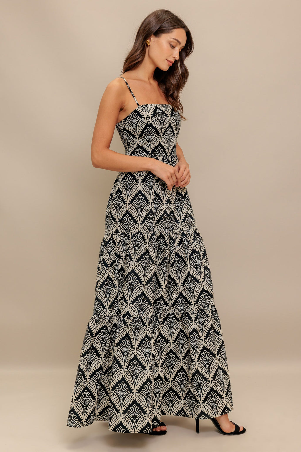 A printed black & ivory woven maxi dress featuring sweetheart neckline, straps, tiered skirt and smocked back bodice