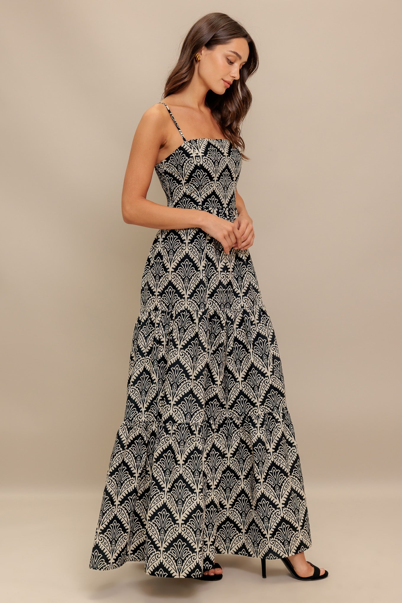 A printed black & ivory woven maxi dress featuring sweetheart neckline, straps, tiered skirt and smocked back bodice