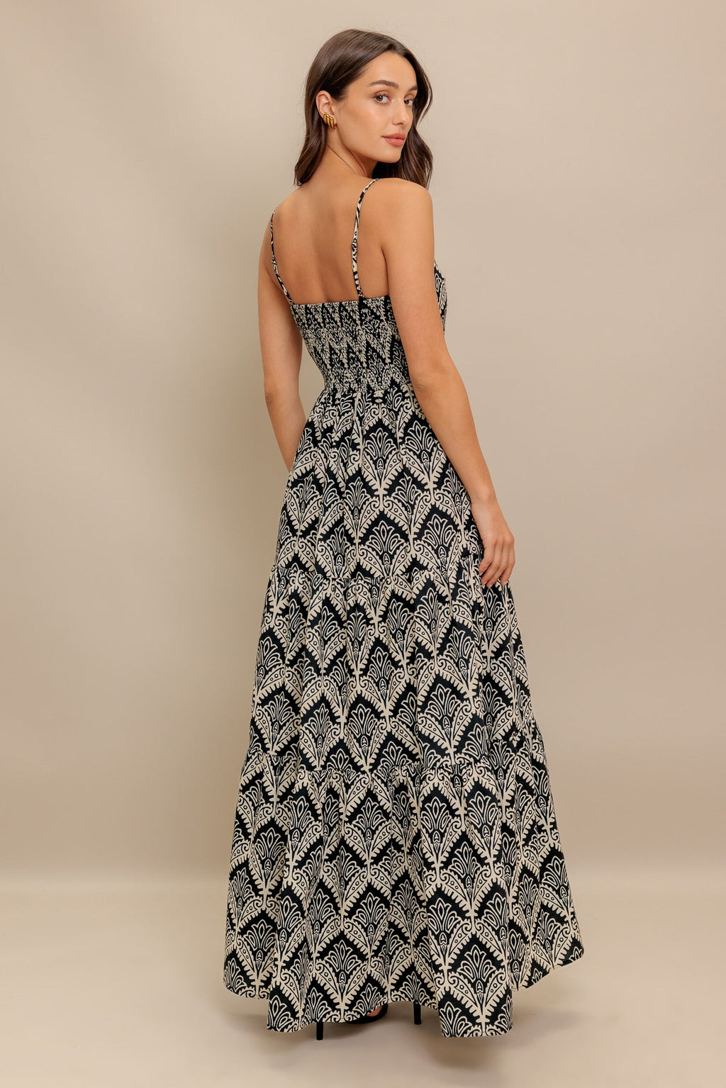 A printed black & ivory woven maxi dress featuring sweetheart neckline, straps, tiered skirt and smocked back bodice