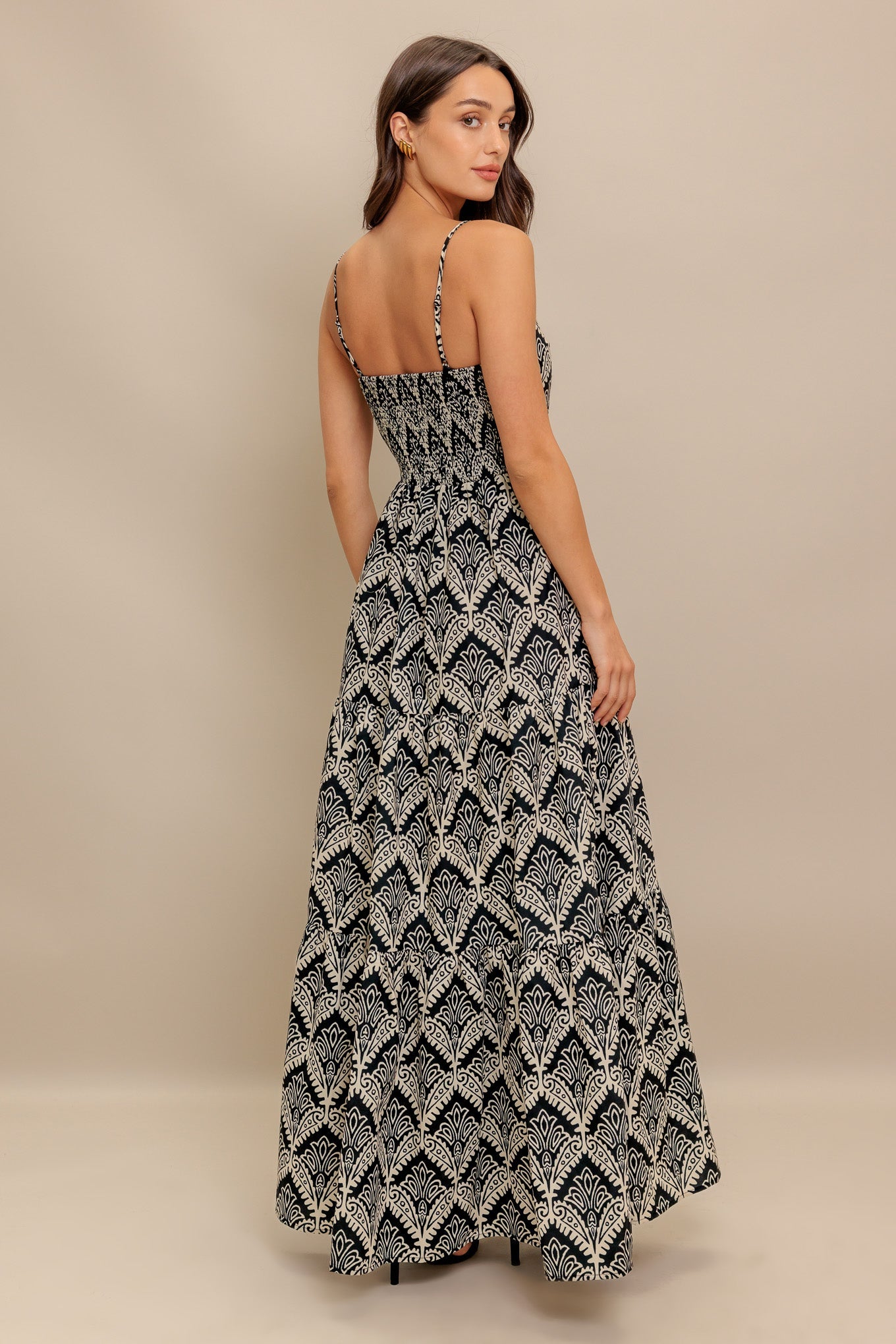 A printed black & ivory woven maxi dress featuring sweetheart neckline, straps, tiered skirt and smocked back bodice